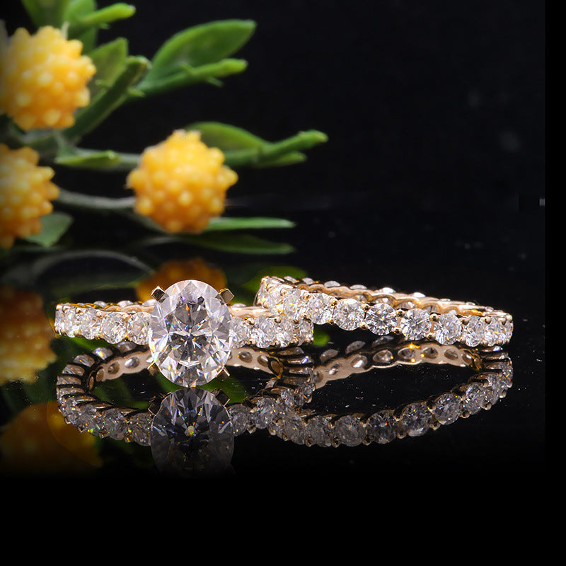 1.5 ct oval Moissanite center stone with side stones, set in 14k yellow gold with matching band